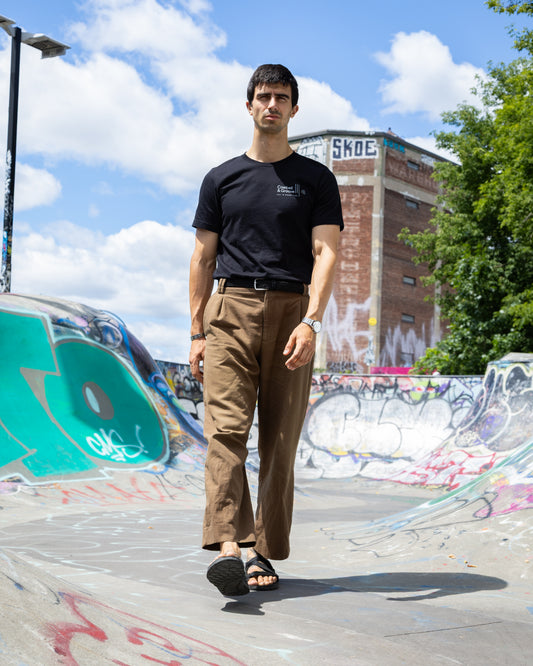 Person wearing Cowbell & Groove minimalist black tee for drummers and musicians